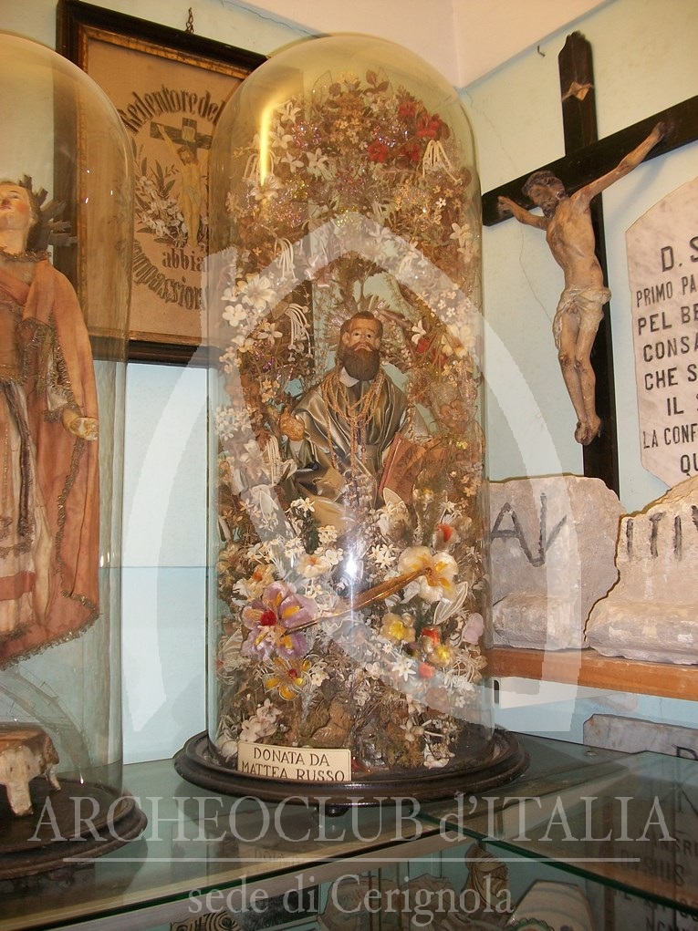 L’ARTISTICA CAMPANA DI SAN MATTEO APOSTOLO EVANGELISTA TRONEGGIA TRA LE CINQUANTA CAMPANE DI VETRO CON STATUE DI SANTI PRESENTI E IN DOTAZIONE NEL MUSEO ETNOGRAFICO CERIGNOLANO (1979)